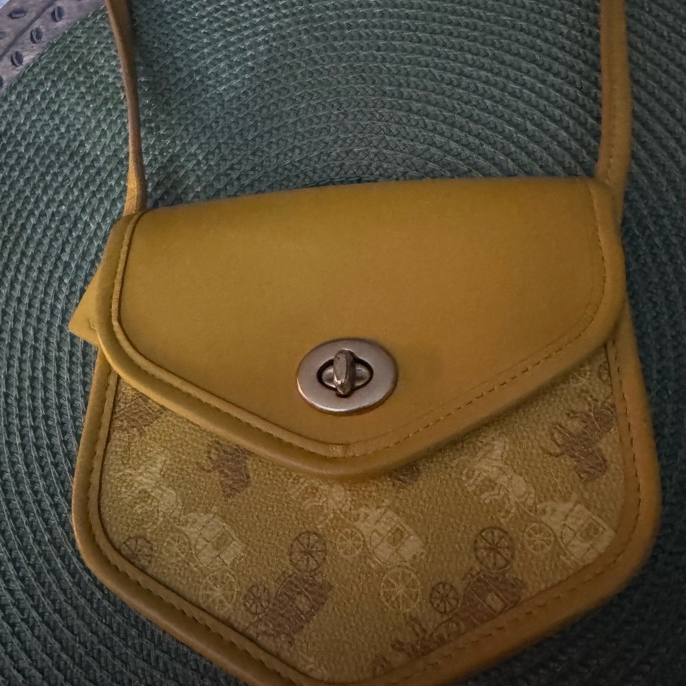 Coach Turnlock Flap Pouch 15 with Horse and Carriage Print in yellow.